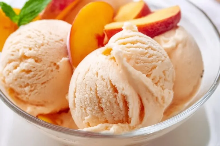 Delicious Peach Greek Frozen Yogurt in a bowl, topped with fresh peaches.