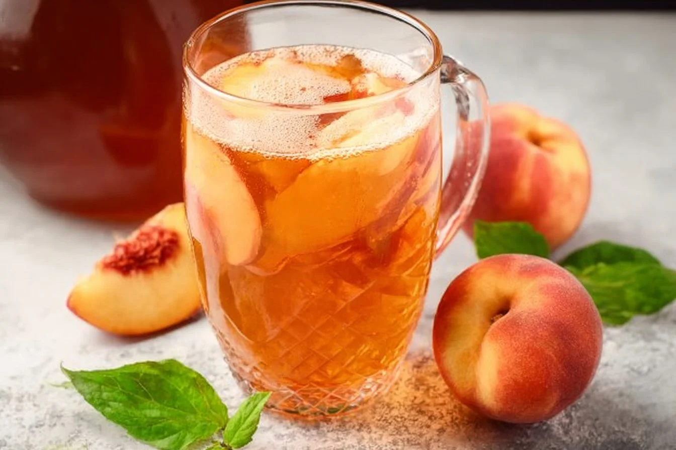 Southern Peach Tea peach tea Glass of Southern peach tea served with fresh peaches and mint leaves